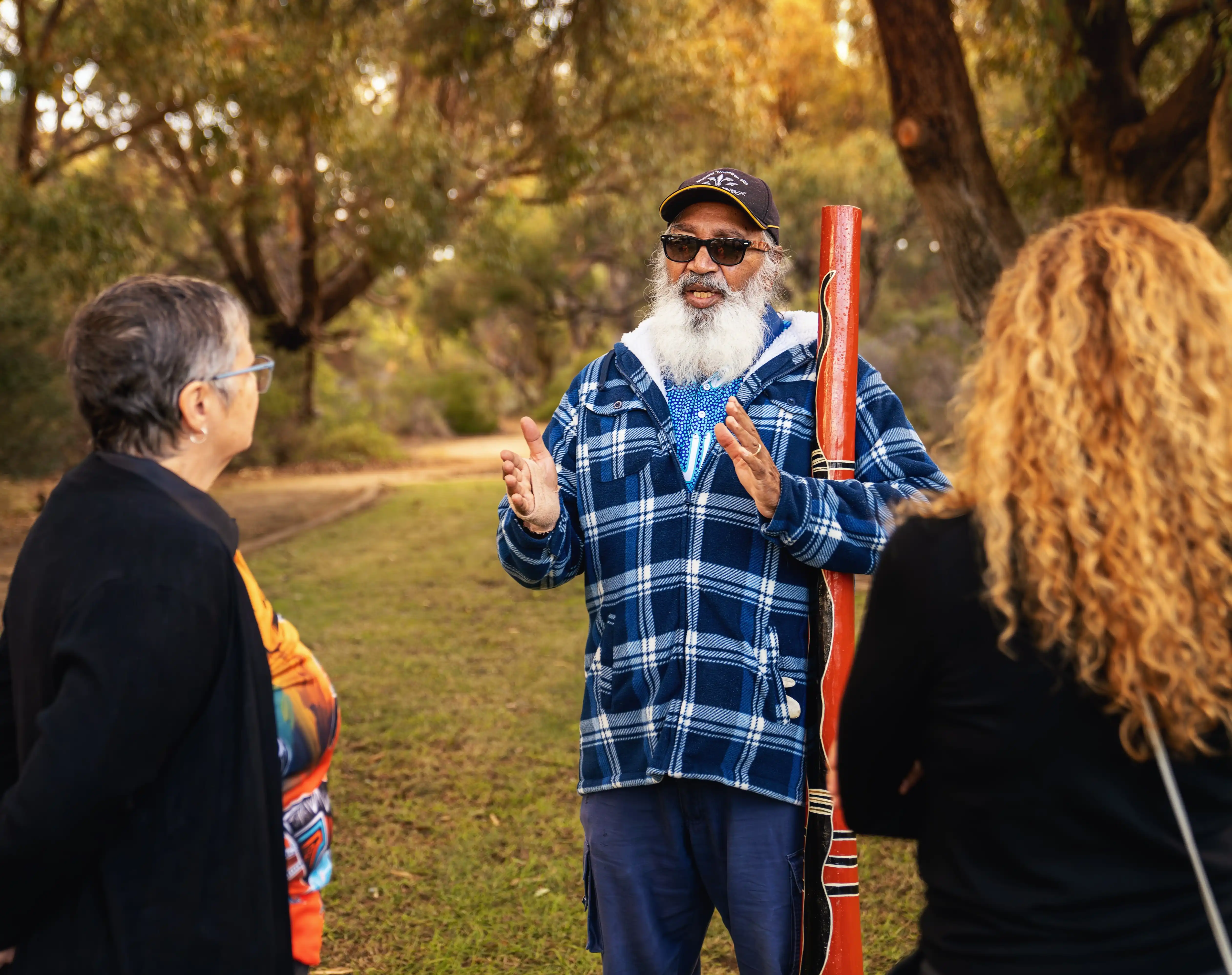 Local Elder, George talking to two people in a nature setting